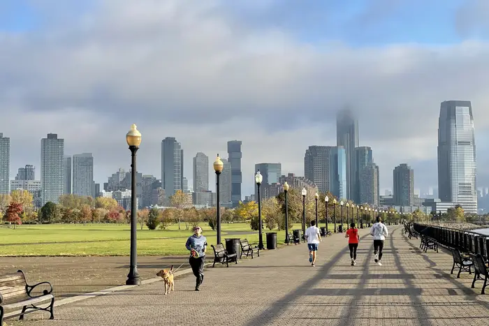 People go for walk at New Jersey's Liberty State Park on a cloudy day in New York City.